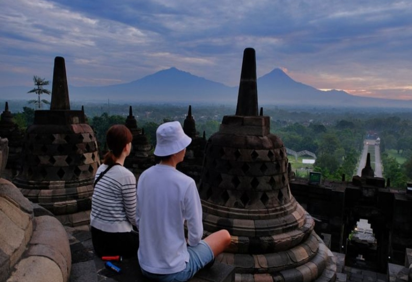 Pengunjung menikmati sunrise dari atas bangunan Candi Borobudur. 