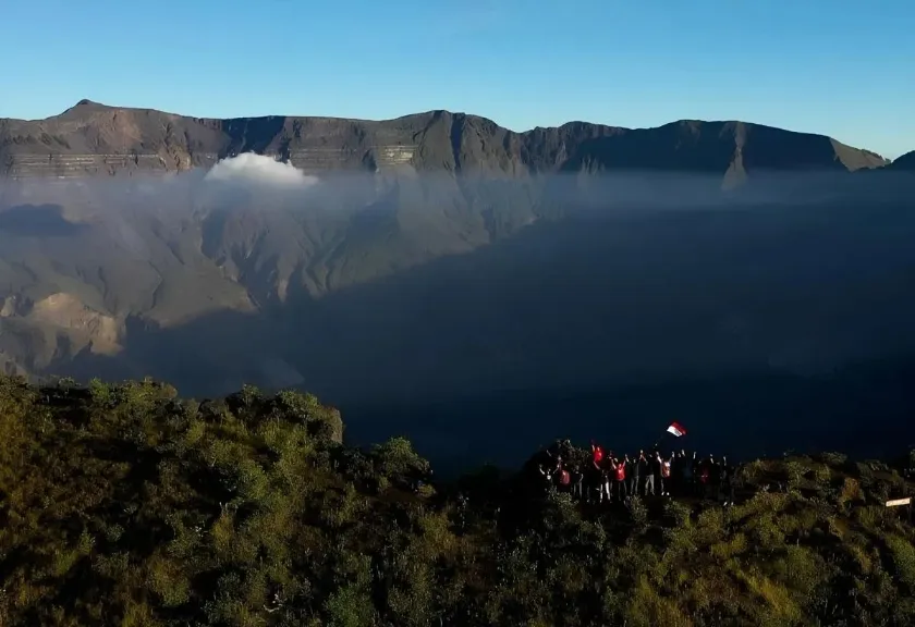 Pendaki menikmati matahari terbit di atas puncak Gunung Tambora