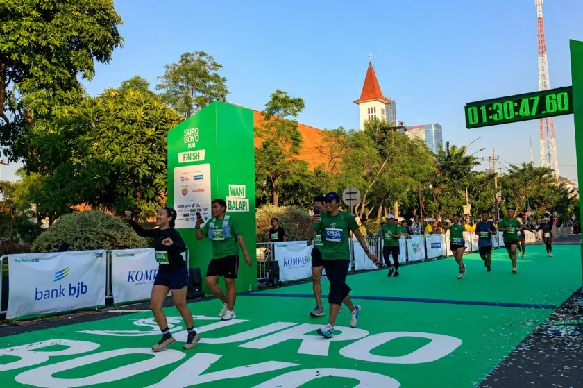 Sejumlah pelari memasuki garis finis dalam ajang lomba lari Suroboyo 10K di Kota Surabaya, Minggu