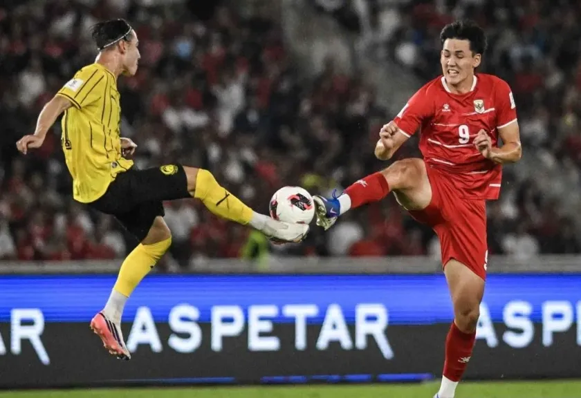 Pemain Timnas Indonesia Mitchell Baker berebut bola dengan pemain Malaysia Dion Cools pada pertandingan FIFA ASEAN Cup 2026.